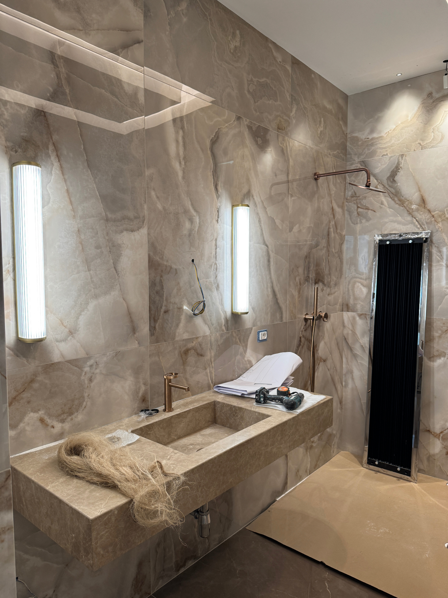 Bagno rivestito in pietra con lavabo monolitico in fase di finitura