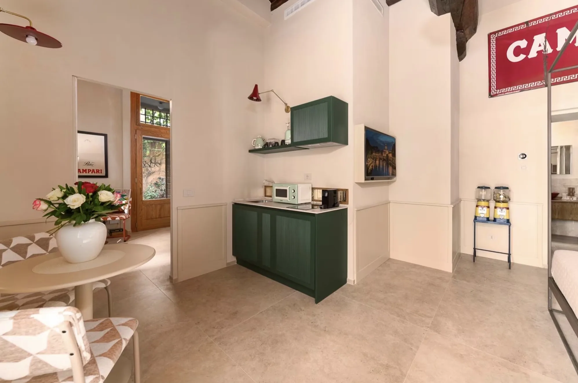 Zona giorno con cucina verde e dettagli Campari