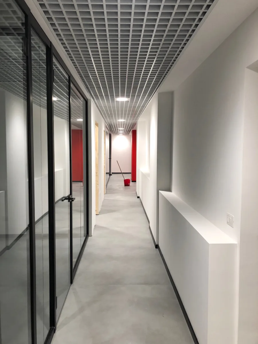 Corridoio completato con pareti vetrate e luce naturale in prospettiva