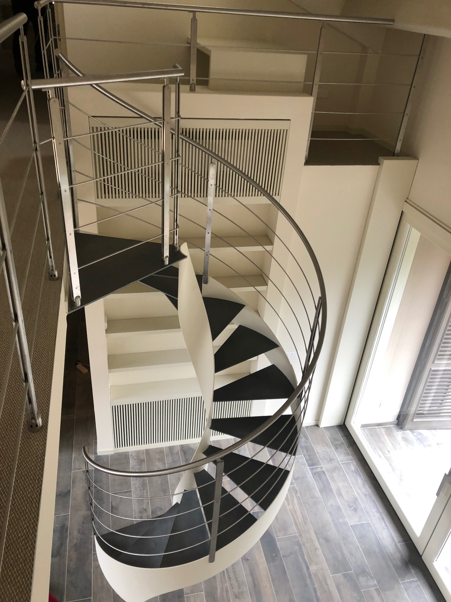 Scala elicoidale con parapetto in acciaio in un interno residenziale