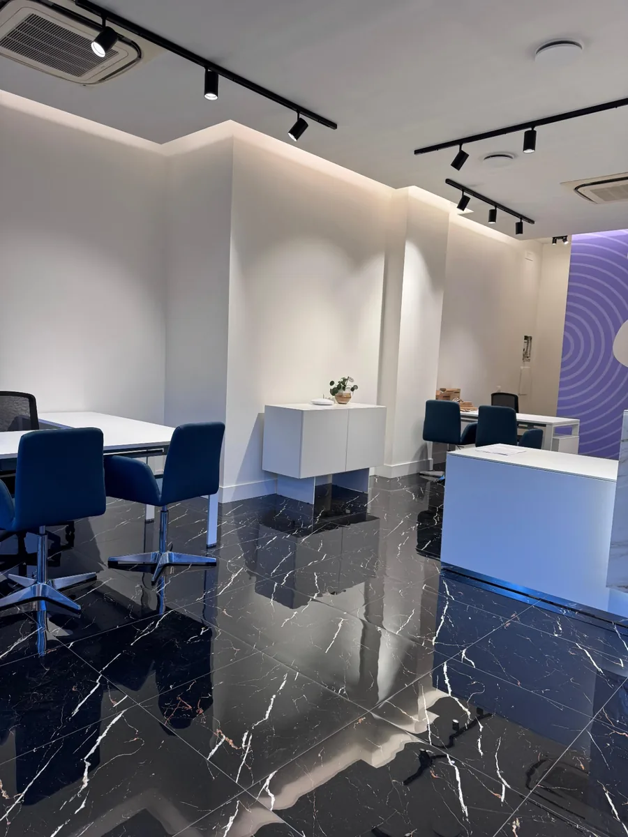 Ambiente completato con pavimento scuro, postazioni e luce integrata