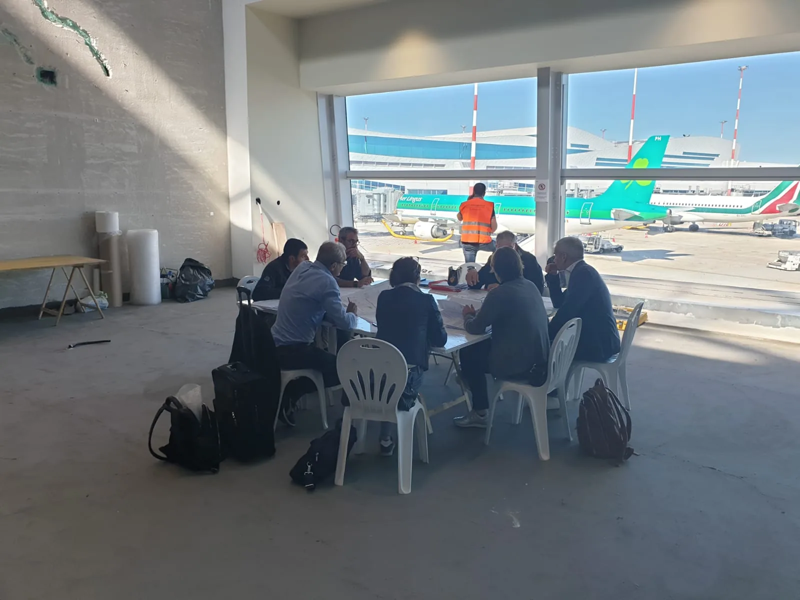 Riunione di coordinamento del cantiere con vista sulle piazzole aeroportuali