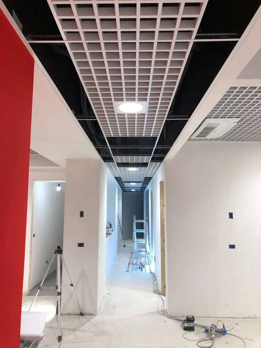 Corridoio degli uffici durante le lavorazioni con controsoffitto a griglia
