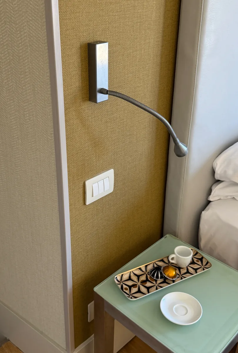 Lampada da lettura e vassoio caffè sul comodino in vetro