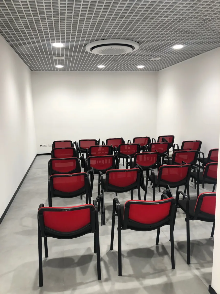Sala formazione completata con sedute e controsoffitto a griglia