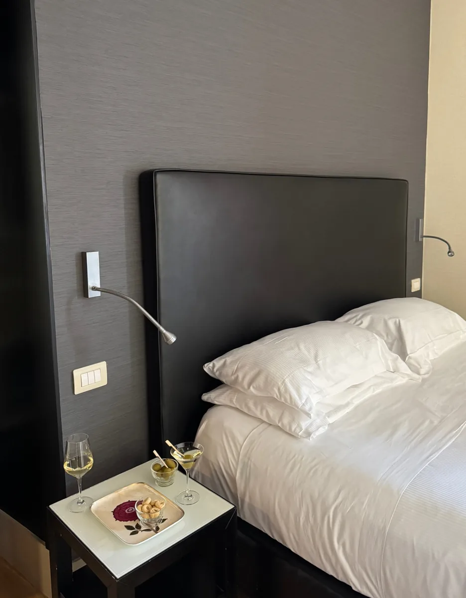 Comodino con vassoio di benvenuto accanto al letto