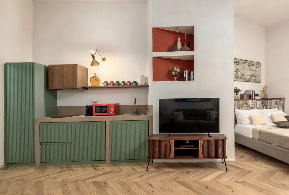 Zona giorno con cucina verde e pavimento a spina