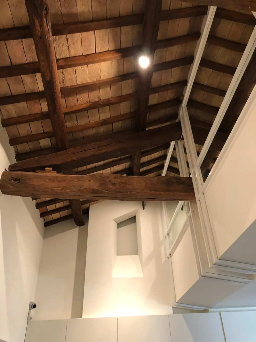 Dettaglio del tetto con travi lignee e strutture bianche