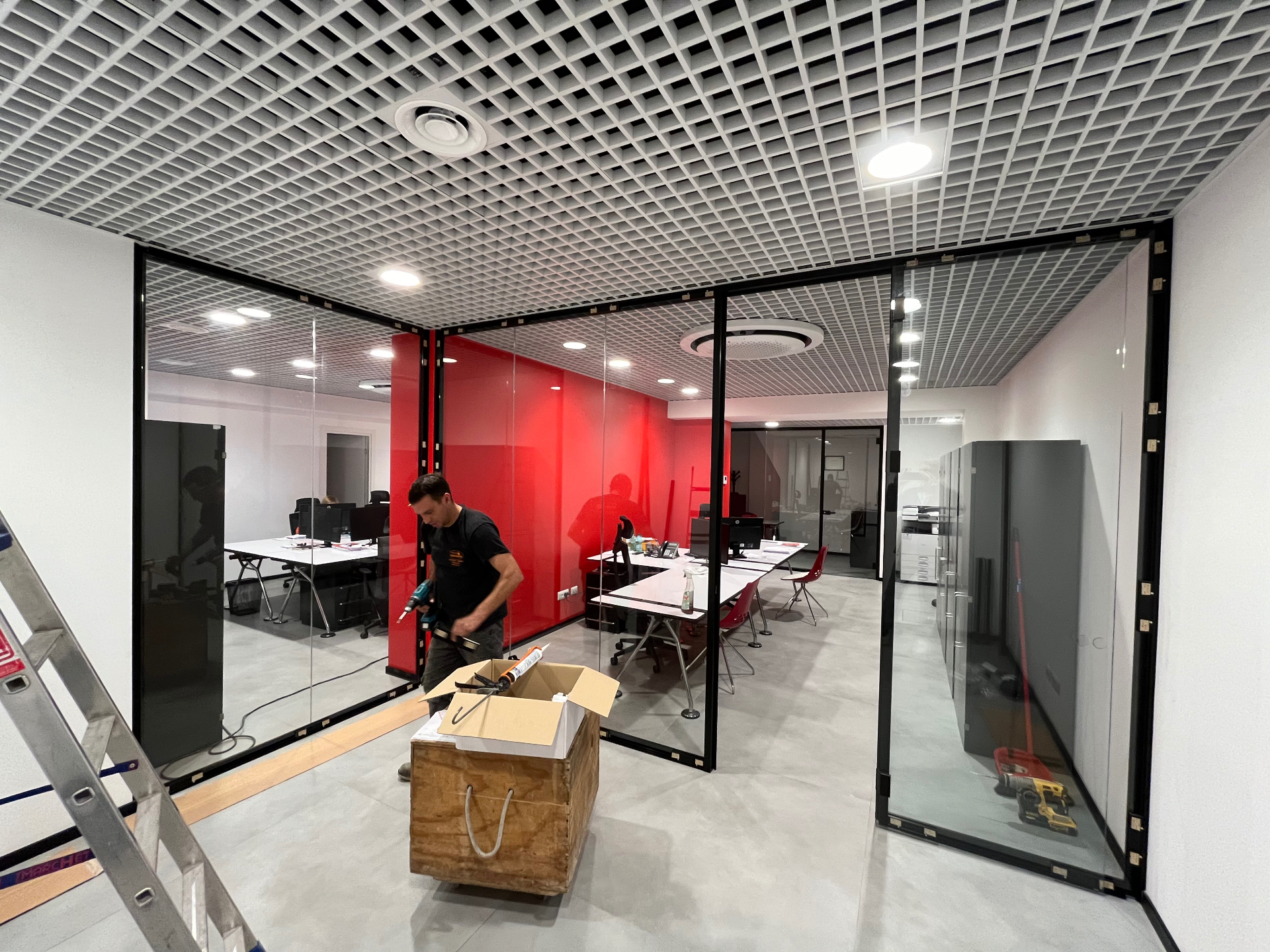 Uffici con pareti vetrate e controsoffitto a griglia in fase di completamento