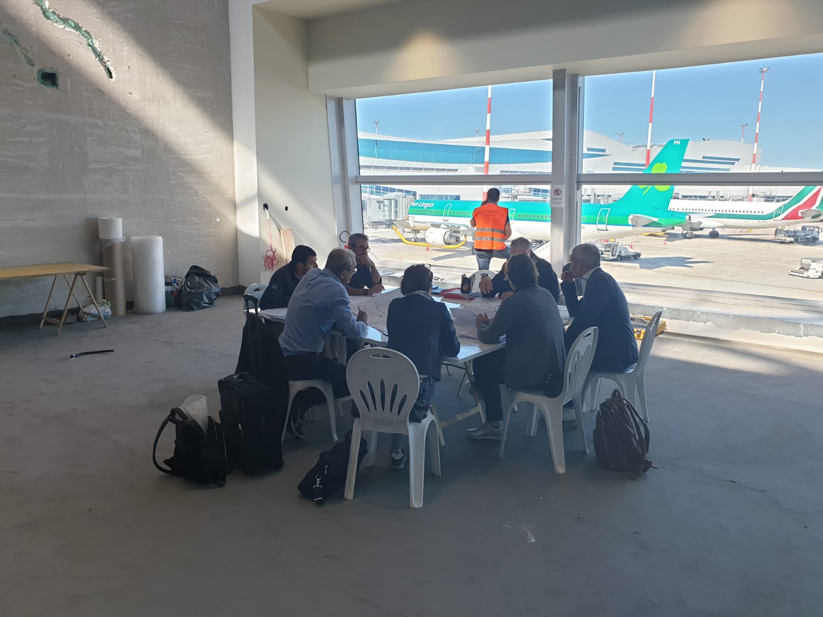 Riunione di coordinamento del cantiere con vista sulle piazzole aeroportuali
